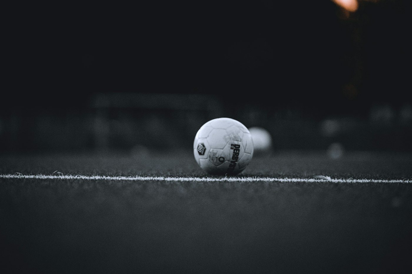 Fotboll på en vit linje i mörkret